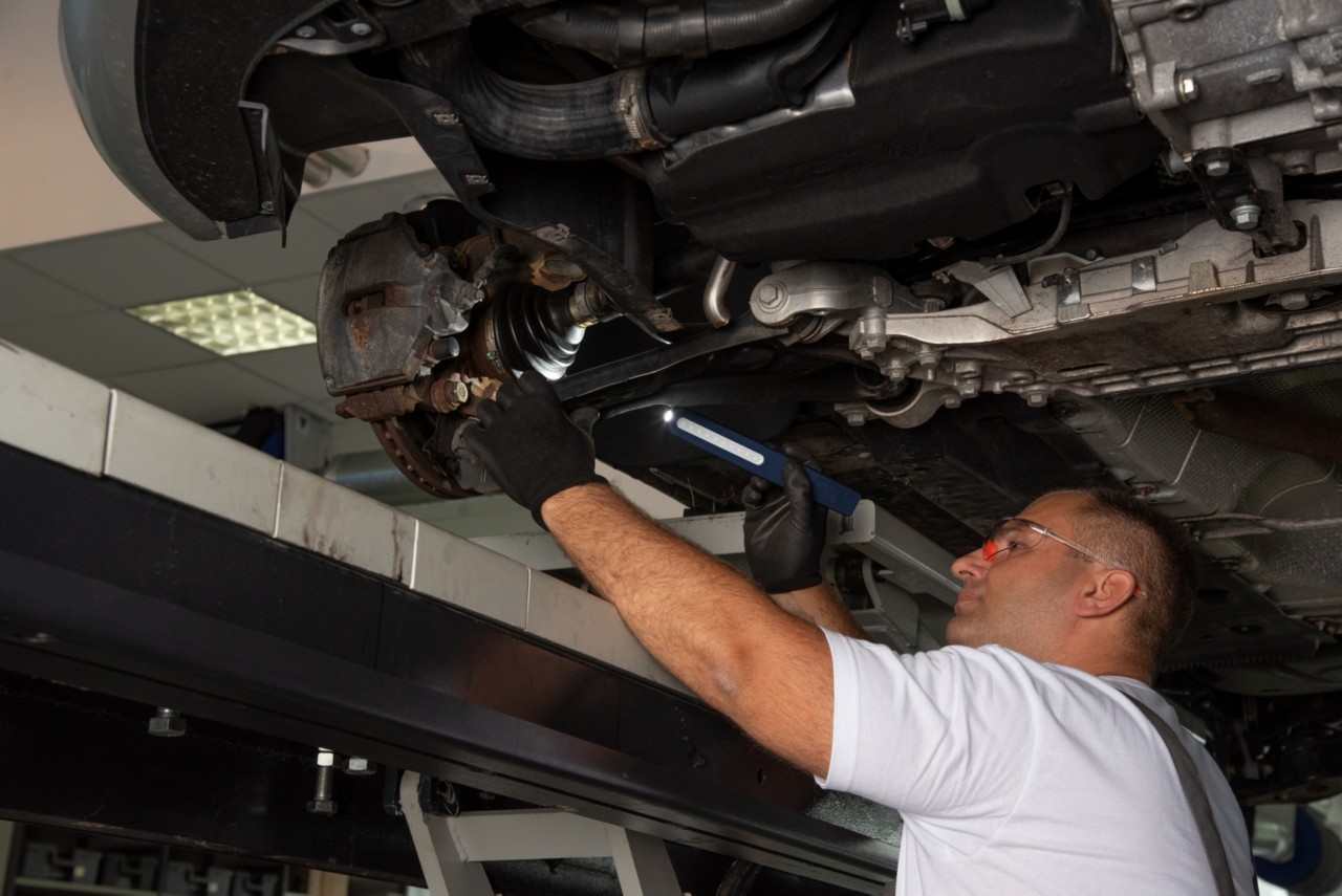 Mechaniker bei der Überprüfung von Lenkungs- und Bremsteilen