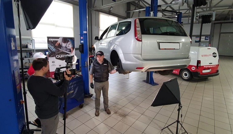 Especialista técnico grabando un vídeo de automoción sobre piezas de freno