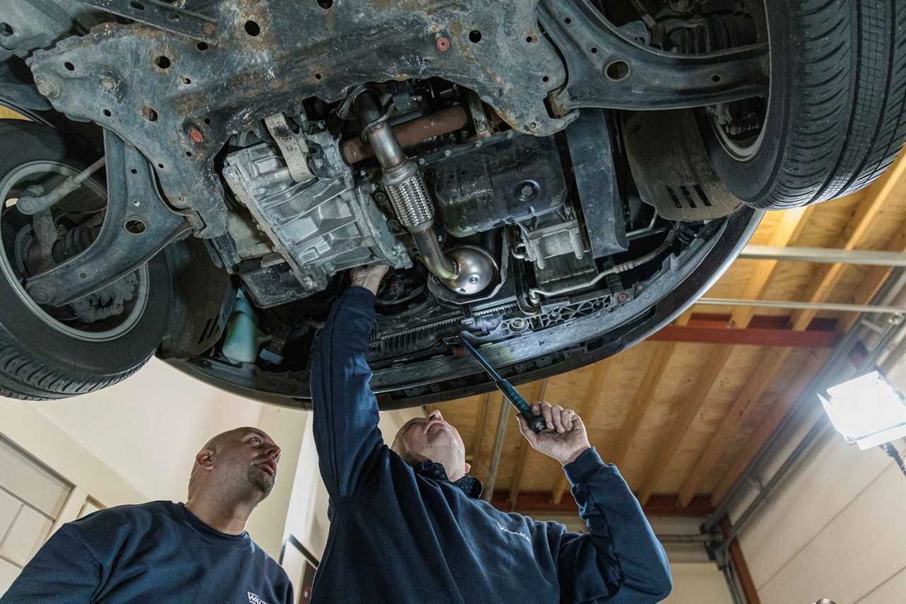 Mechanics checking emissions control system