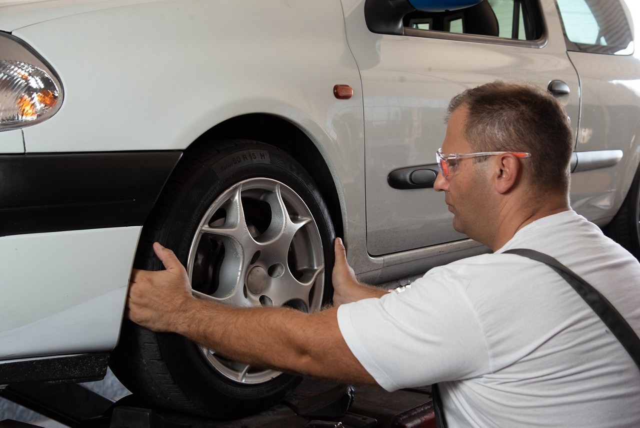 mécanicien faisant l'alignement des roues